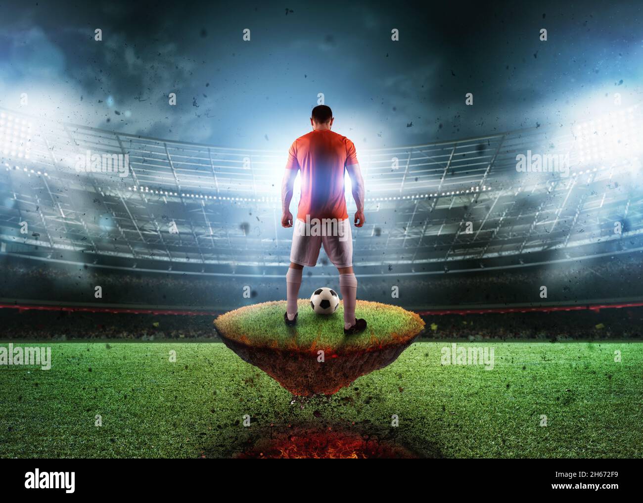 Fußballspieler auf einem feurigen Feld bereit, den Ball zu treten Stockfoto