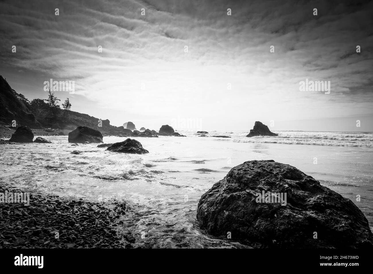 Schwarze und weiße Felsen am Ufer des indischen Strandes Stockfoto