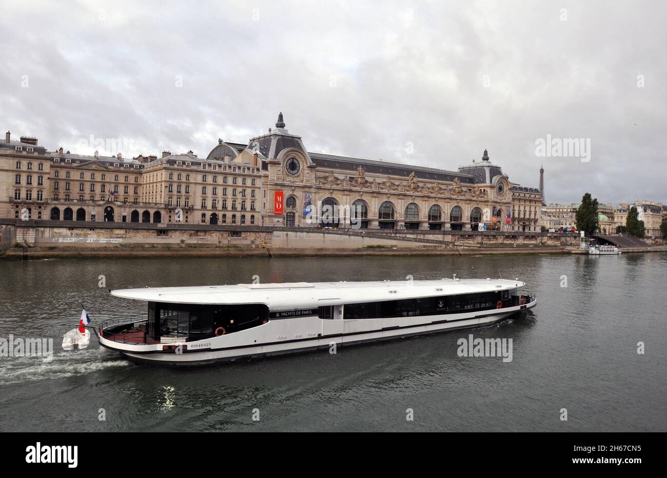 Ein Boot fährt entlang der seine in Paris am Wahrzeichen Musée d'Orsay vorbei, einem Kunstmuseum im historischen ehemaligen Bahnhof Gare d'Orsay. Stockfoto