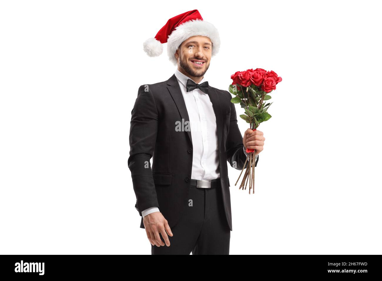 Junger Mann mit einem Weihnachtsmannhut, der ein paar rote Rosen auf weißem Hintergrund hält Stockfoto