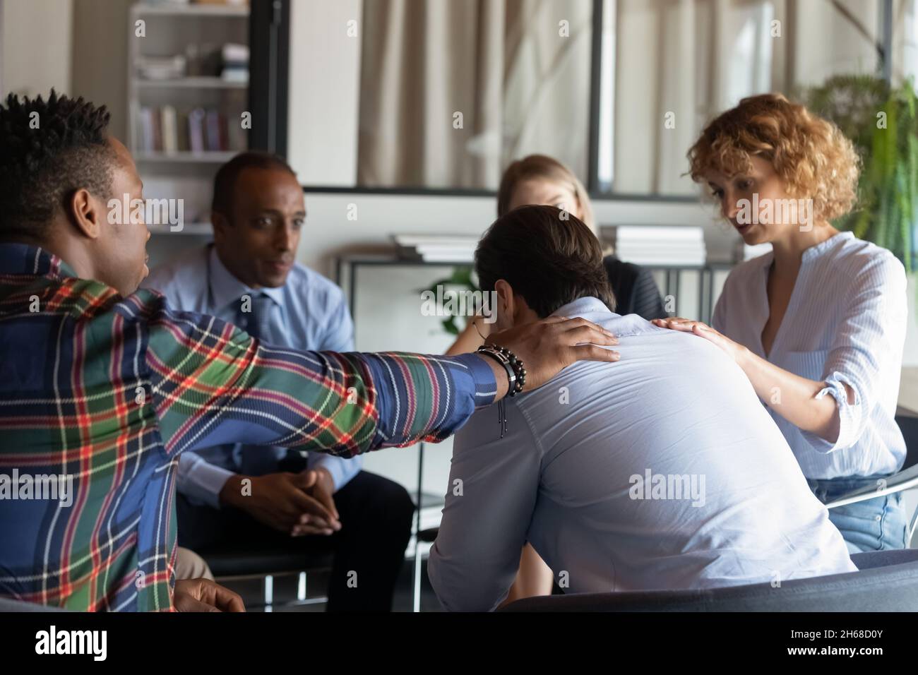 Mitfühlende junge, vielfältige Geschäftsleute, die depressive Kollegen unterstützen. Stockfoto