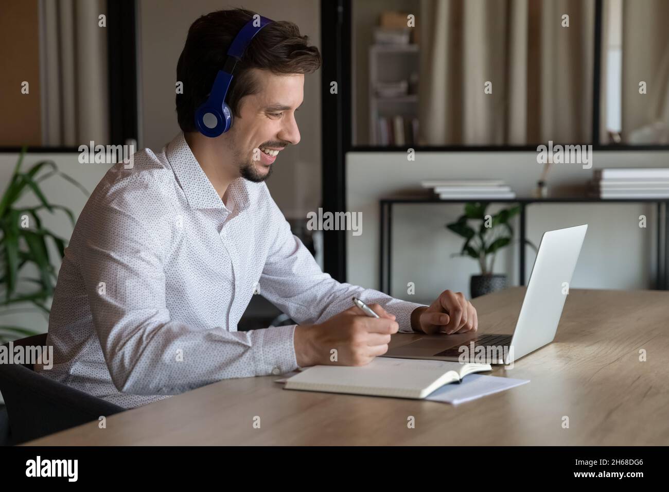 Glücklicher junger hispanischer Geschäftsmann, der sich mit Videoanrufen befreute. Stockfoto