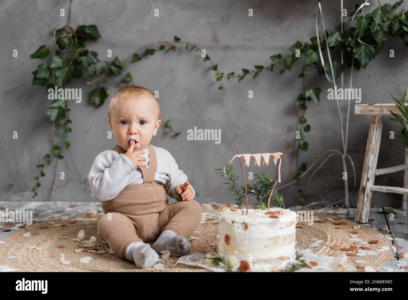 Erster Geburtstag eines kleinen Jungen, der Kuchen isst, ein einjähriges Kleinkind. Kind mit Kuchen im Studio. Kindergeburtstag Stockfoto