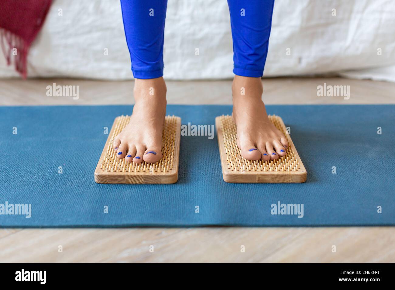 Frau, die auf Sadhu-Brettern mit scharfen Nägeln steht. Nahaufnahme der Füße. Stockfoto