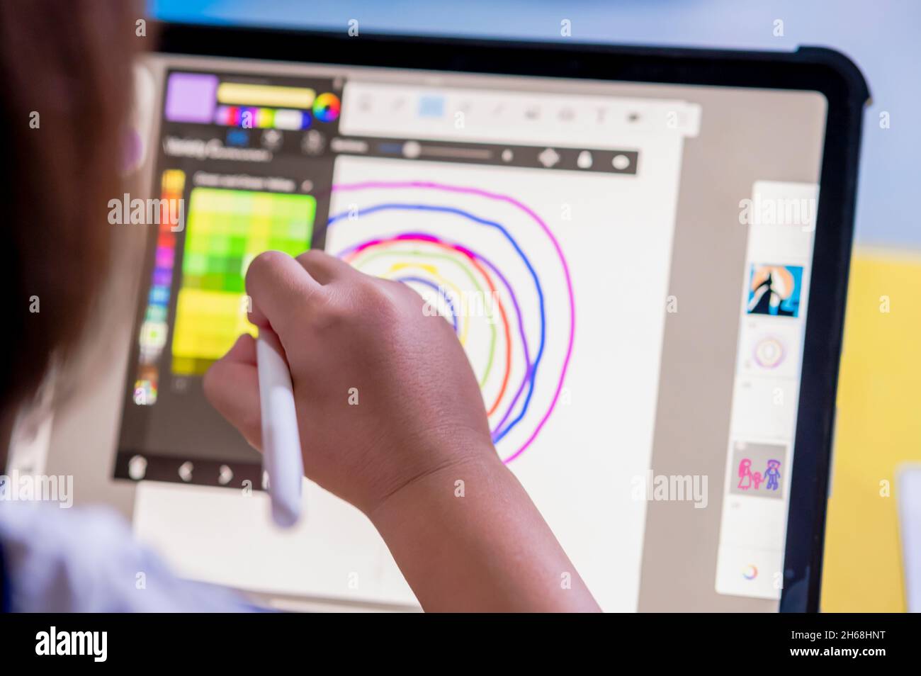 Kleines Mädchen mit einem digitalen Stift und Zeichnung auf Tablet-Touchscreen-Pad mit digitalem Bleistift, um kreativ zu sein und digitale Kunst und Lernen zu Hause zu machen Stockfoto