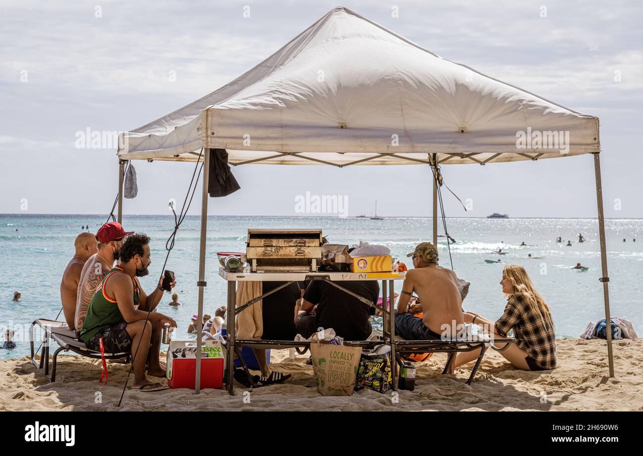 Waikiki, Honolulu, Hawaii - 31. Oktober 2021-Familie genießt ein Picknick unter ihrem eigenen Dach am Strand. Stockfoto