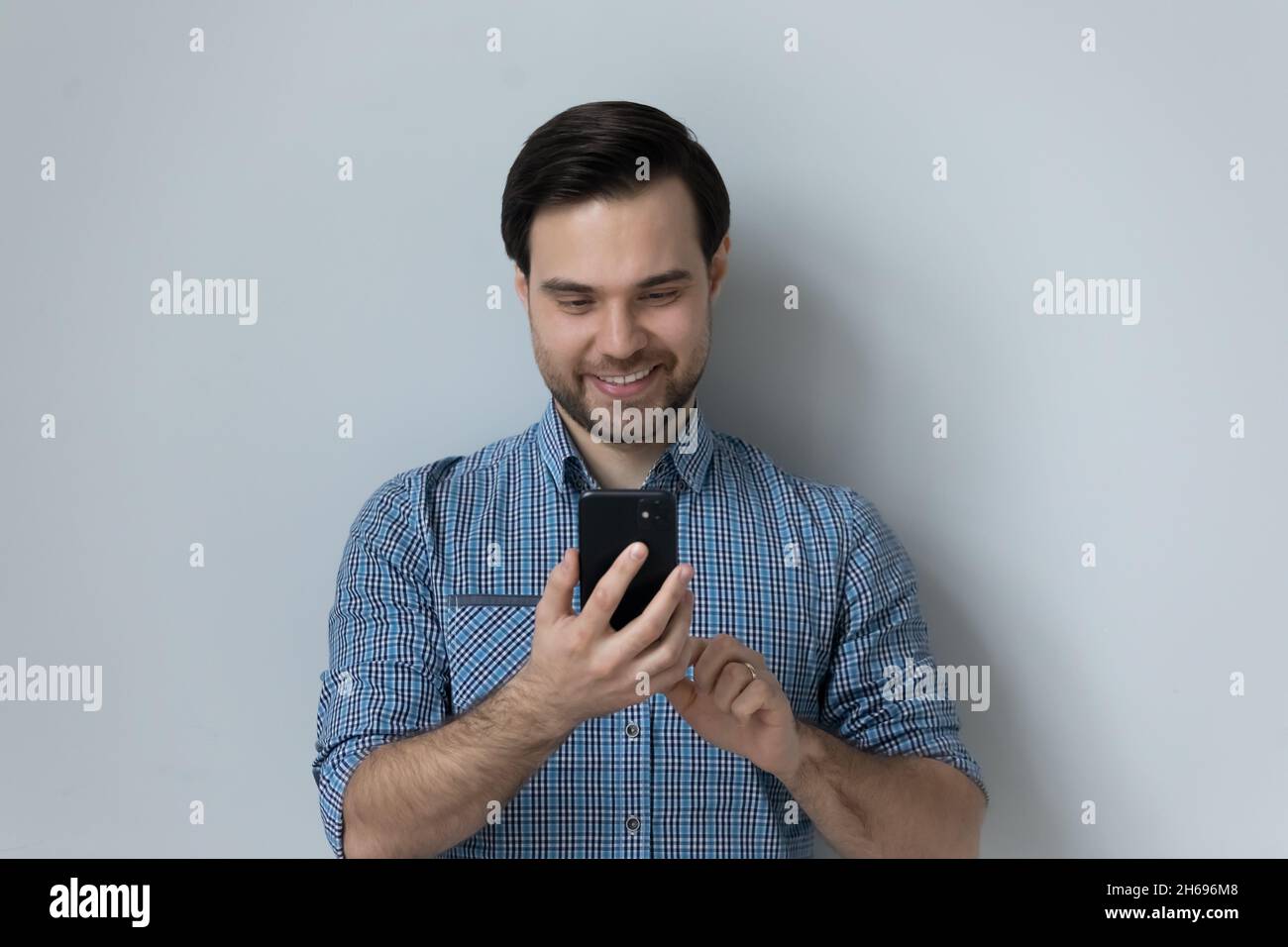 Glücklicher junger Mann, der mobile Softwareanwendungen verwendet. Stockfoto