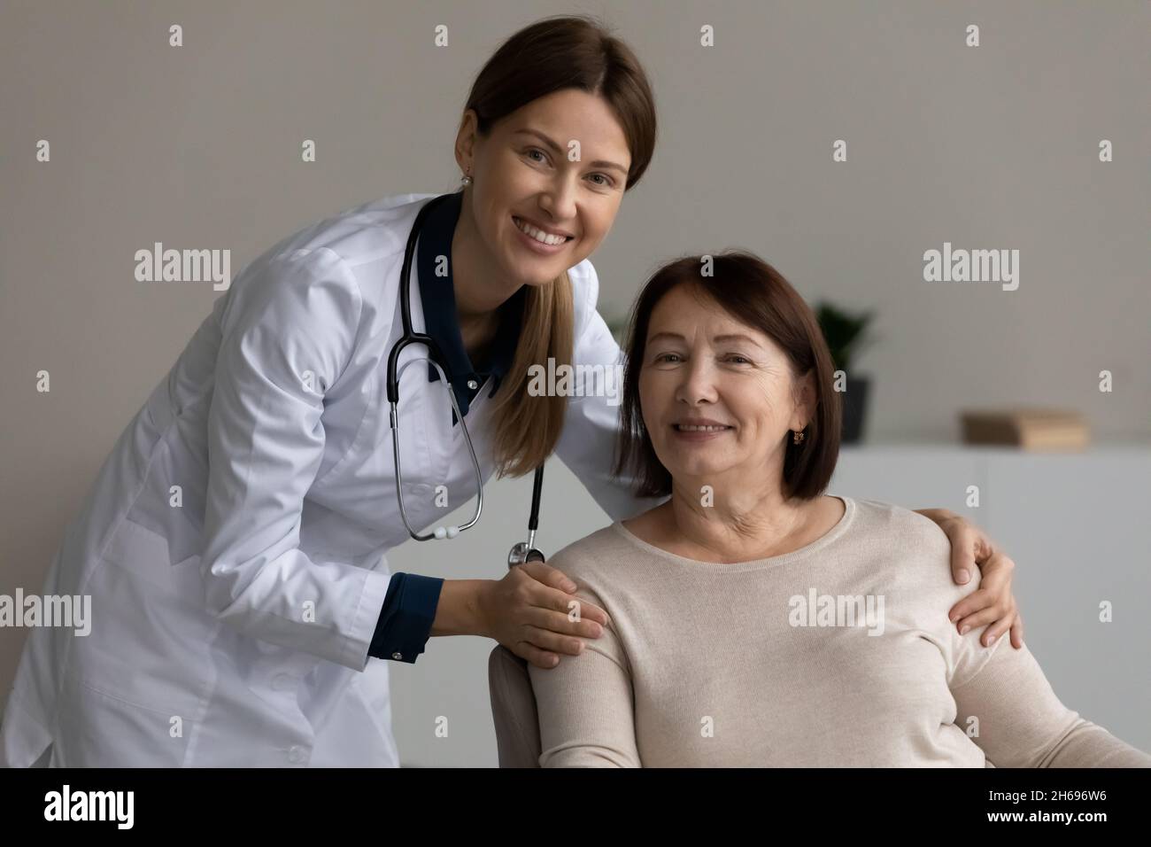 Kopfaufnahme Porträt lächelnde weibliche Therapeutin berühren reifen Patienten Schultern Stockfoto