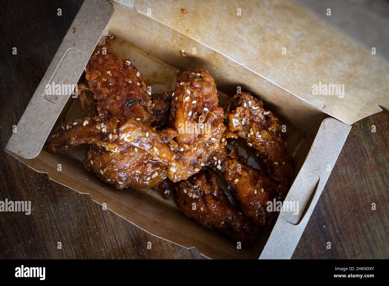 Koreanische gebratene Hühnerflügel und Trommets in einer Take-Away-Box. Traditionelles asiatisches Rezept. Stockfoto