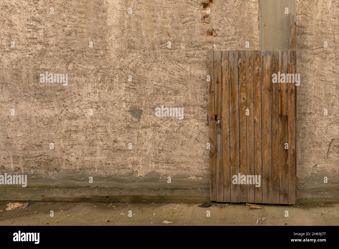 Alte Holztür vor einer schmutzigen Fassade Stockfoto
