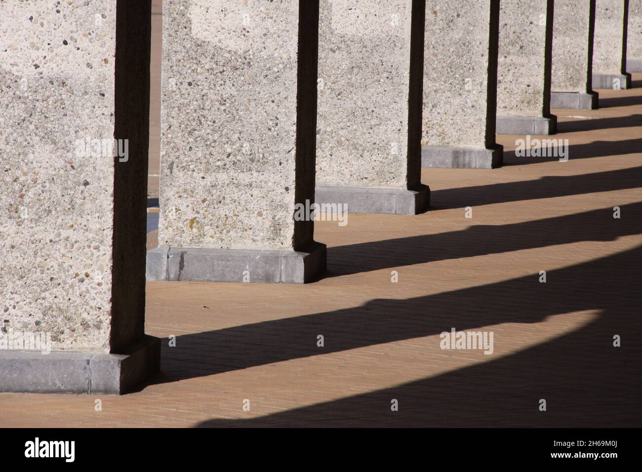 Teil einer Reihe von Betonsäulen in der Sonne. Koninklijke en Venetiaanse gaanderijen België. Stockfoto