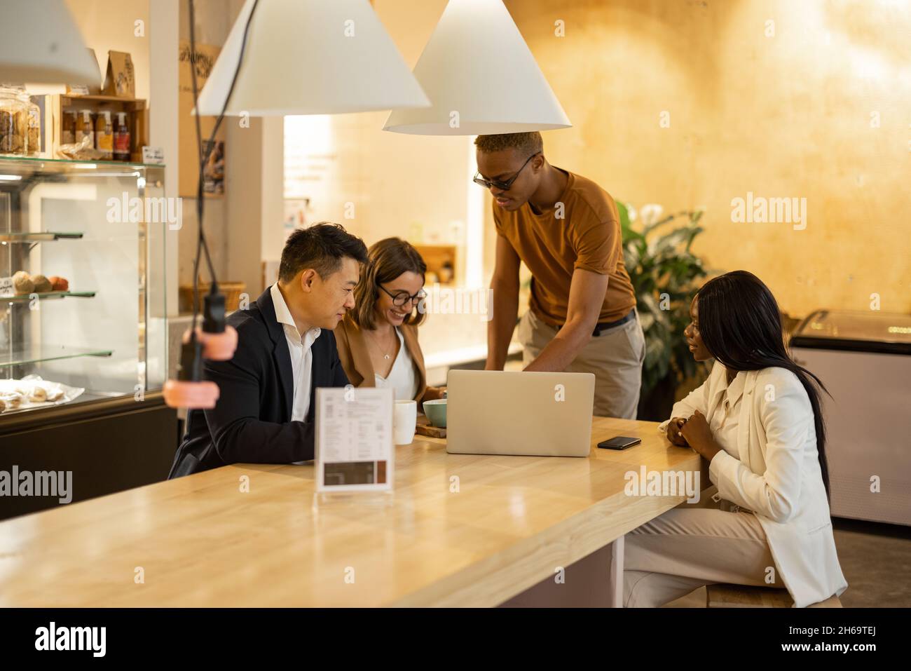 Das Business-Team schaut sich im Café etwas auf dem Laptop an Stockfoto
