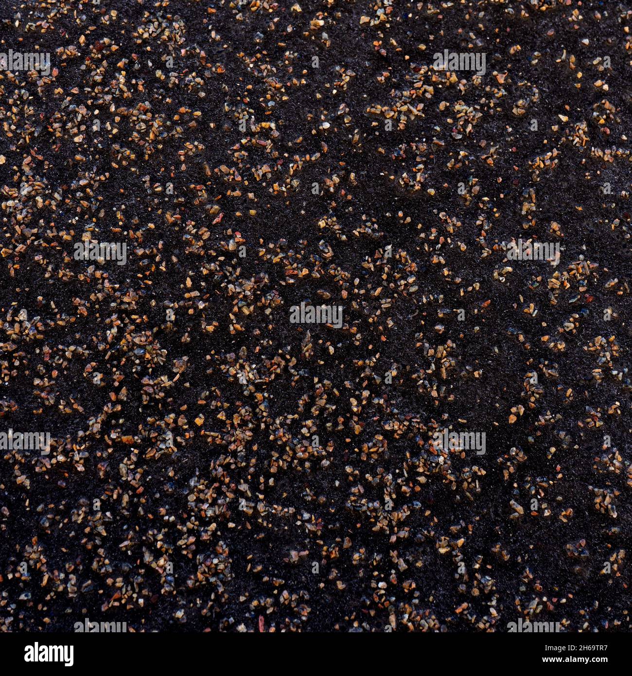 Dunkle Grunge-Textur mit kleinen hellen Kieselsteinen Stockfoto