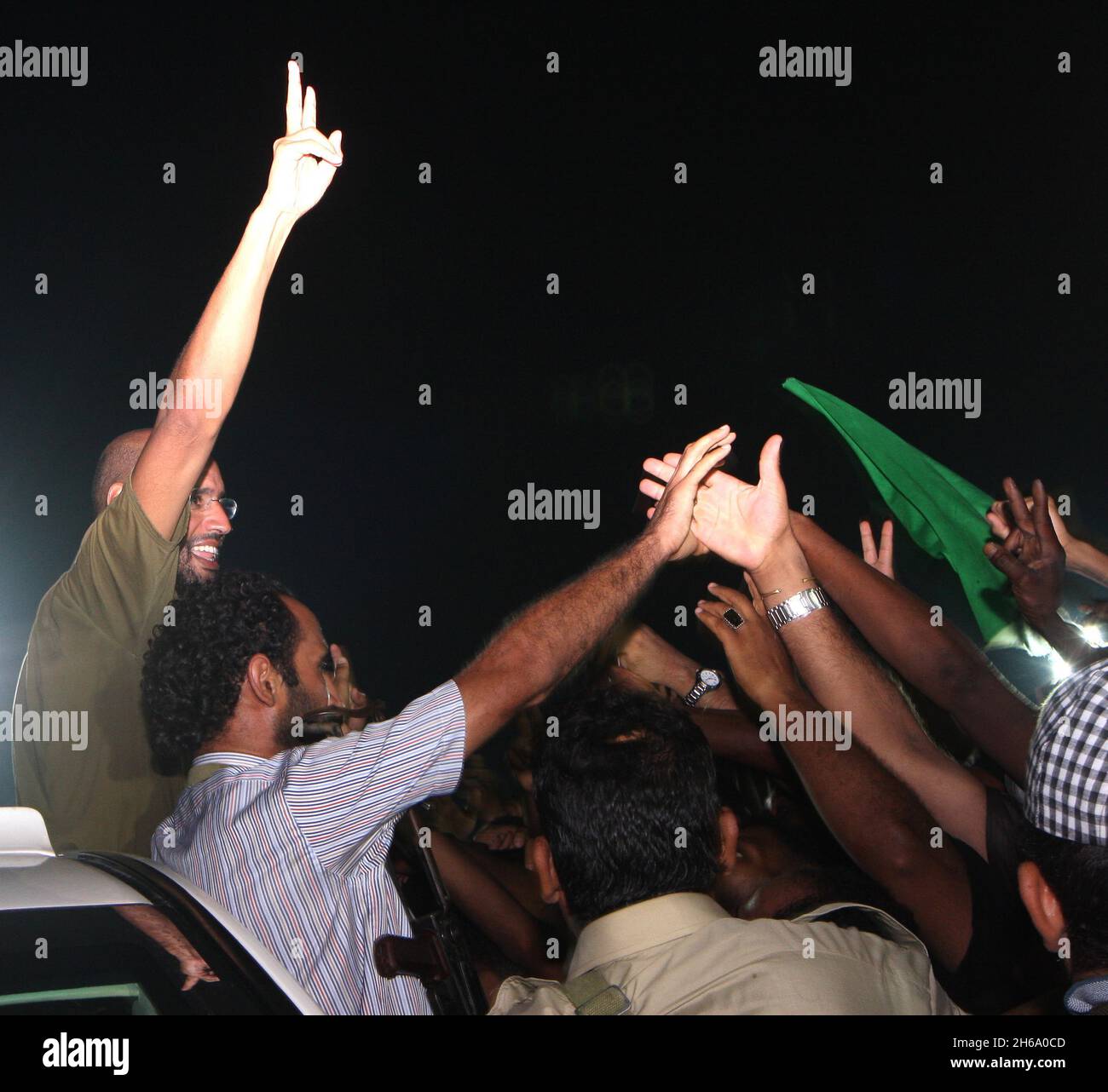 Seif El Islam Gaddafi (L), Sohn des libyschen Führers Muammar Gaddafi, trifft sich in den frühen Morgenstunden des 23. August 2011, einen Tag nach dem Sturz der libyschen Hauptstadt und der Bekanntgabe von Seifs Gefangennahme durch Rebellen, mit Unterstützern in der Bab Al Aziziya-Kaserne in Tripolis, Libyen. Poolfoto via Balkis Press/ABACAPRESS.COM Stockfoto