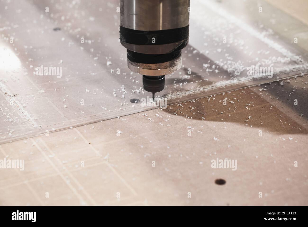 Endfräser verarbeitet transparente Kunststoffbleche auf einer CNC-Fräsmaschine, Nahaufnahme mit selektivem Weichfokus Stockfoto