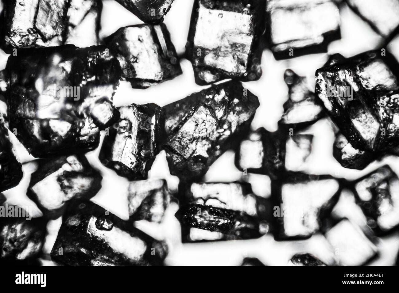 Kristallzucker Nahaufnahme auf weißem Hintergrund unter dem Lichtmikroskop mit einer Vergrößerung von 40-facher Vergrößerung Stockfoto