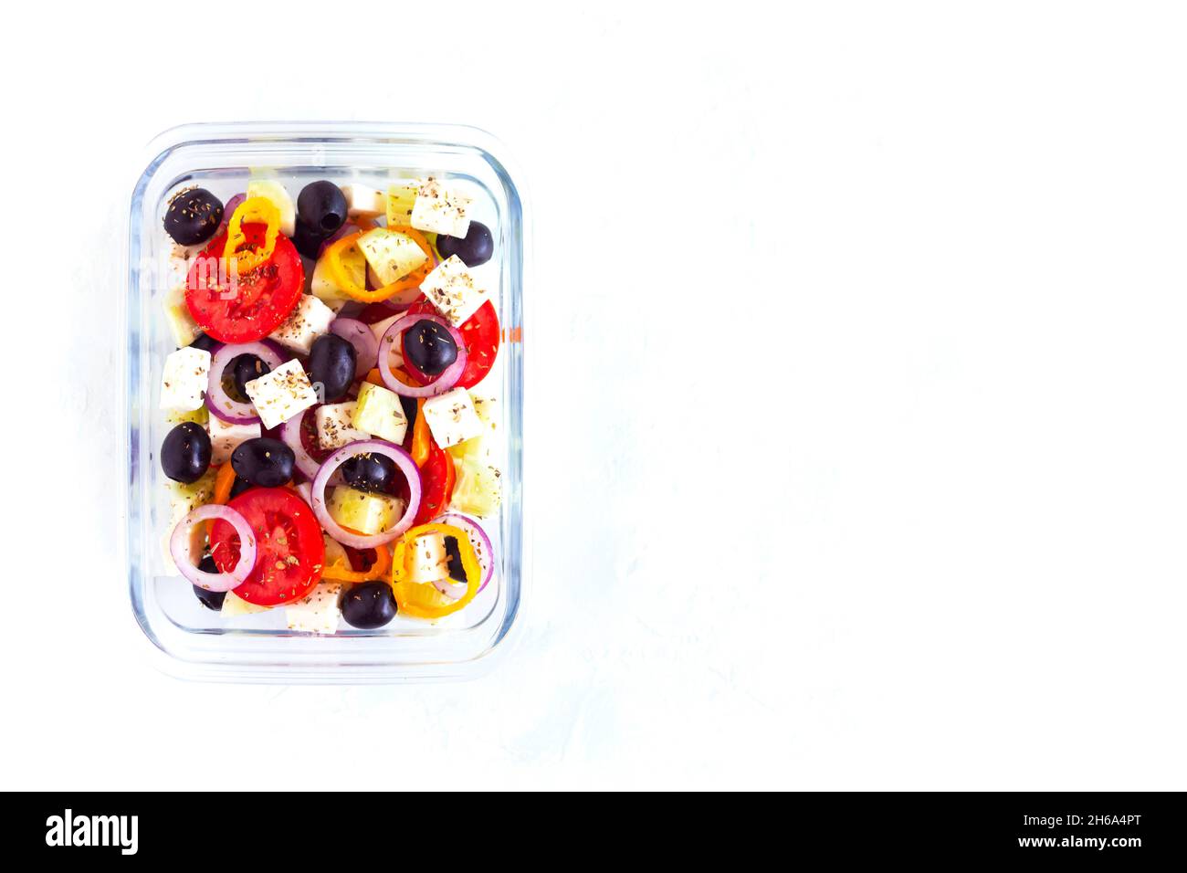 Lunchbox mit griechischem Salat, Konzept für gesunde Lebensmittel und Zero Waste, auf weißem Hintergrund, Draufsicht, Kopierraum Stockfoto
