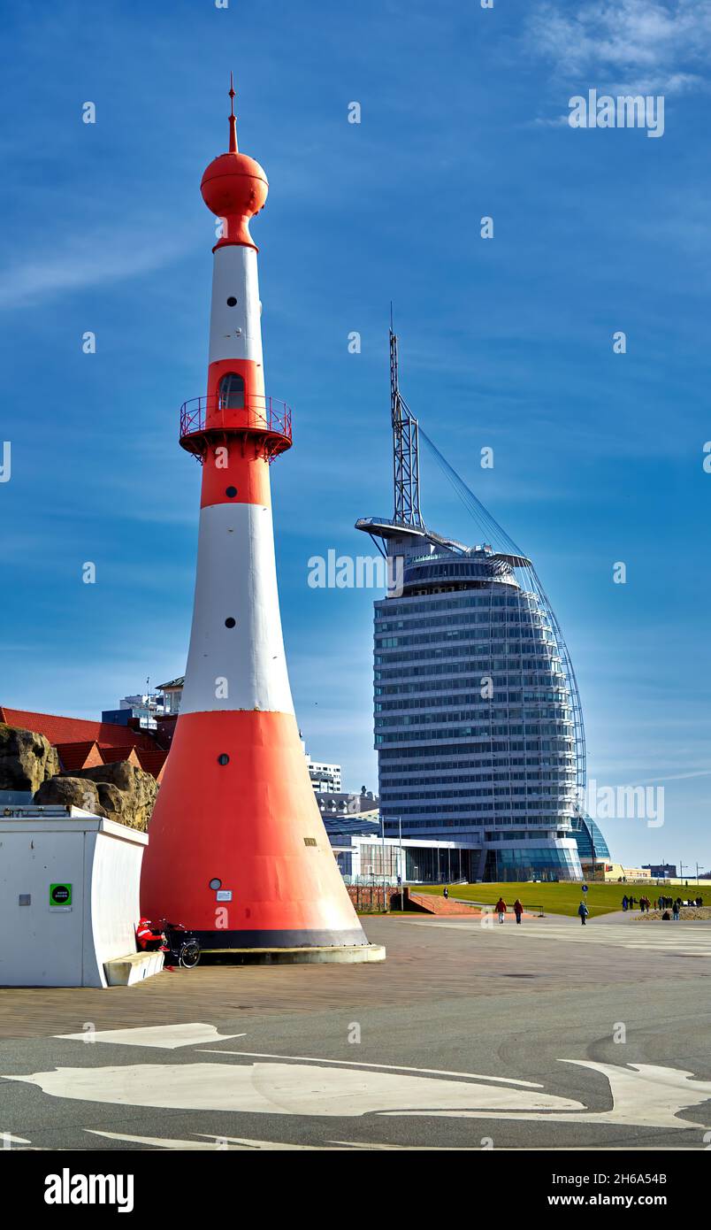 Bremerhaven, 24. Februar 2021: Leuchtturm vor dem Zoo am Meer mit dem Atlantic Hotel Sail City im Hintergrund Stockfoto