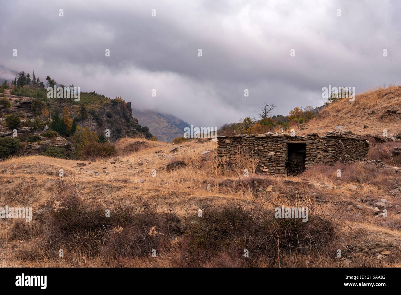 Typisches Haus auf den Gipfeln der Sierra Nevada in Granada, aus Steinen und Ton, um Vieh zu halten. Stockfoto