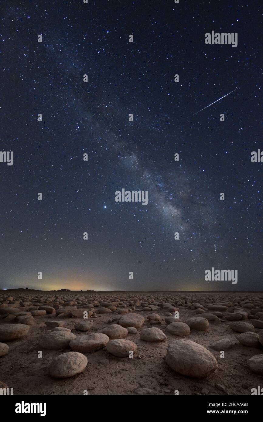 Sternschnuppe über einem Wüstenfeld aus Kalksteinen in der Nacht Stockfoto