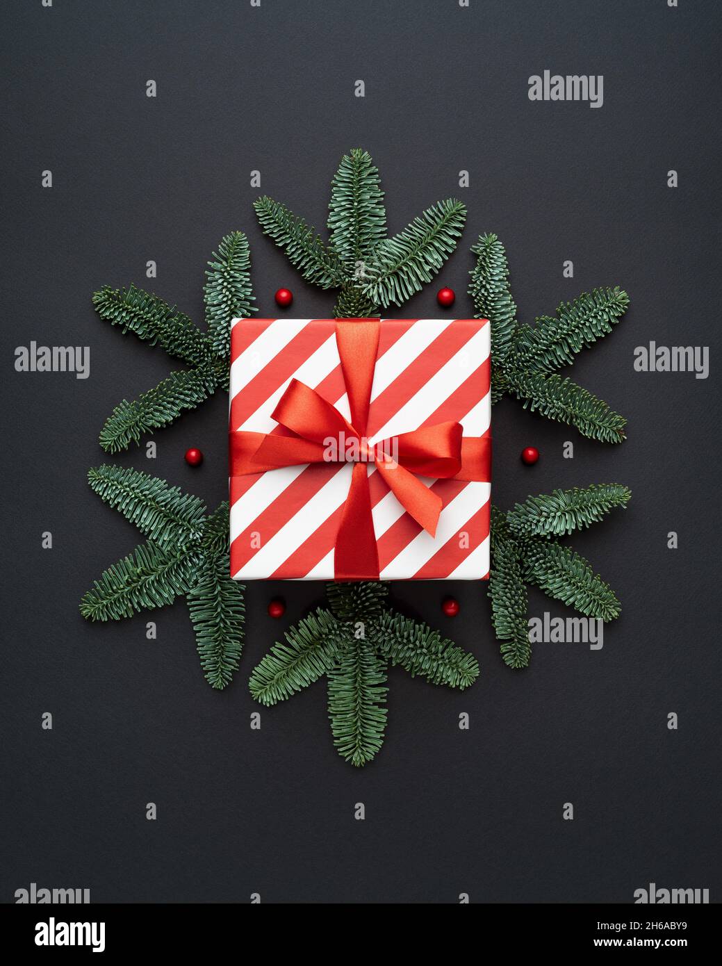 Weihnachtskarte mit Geschenkbox und dekorativer Schneeflocke auf schwarzem Hintergrund Stockfoto