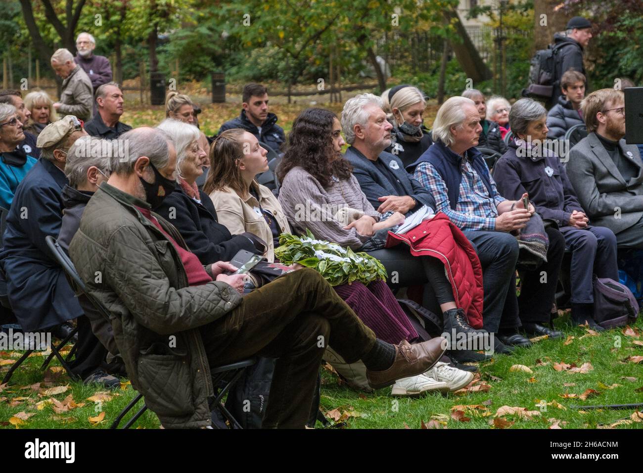 London, Großbritannien. November 2021. Die von der Kampagne „Weißer Mohn für den Frieden“ auf dem Tavistock-Platz organisierte Nationale Gedenkzeremonie stellt sich den Ungerechtigkeiten des Krieges, erinnert an all seine Opfer, militärische und zivile, und steht für Frieden. Nachdem Sprecher von „Body Count“ im Irak und ein palästinensischer Aktivist darüber sprachen, in Jerusalem und Gaaza unter ständiger Bedrohung zu leben, kam es zu einem 2-minütigen Schweigen, bevor Kränze und weißer Mohn an der Gedenkstätte für Kriegsdienstverweigerer gelegt wurden. Peter Marshall/Alamy Live News Stockfoto