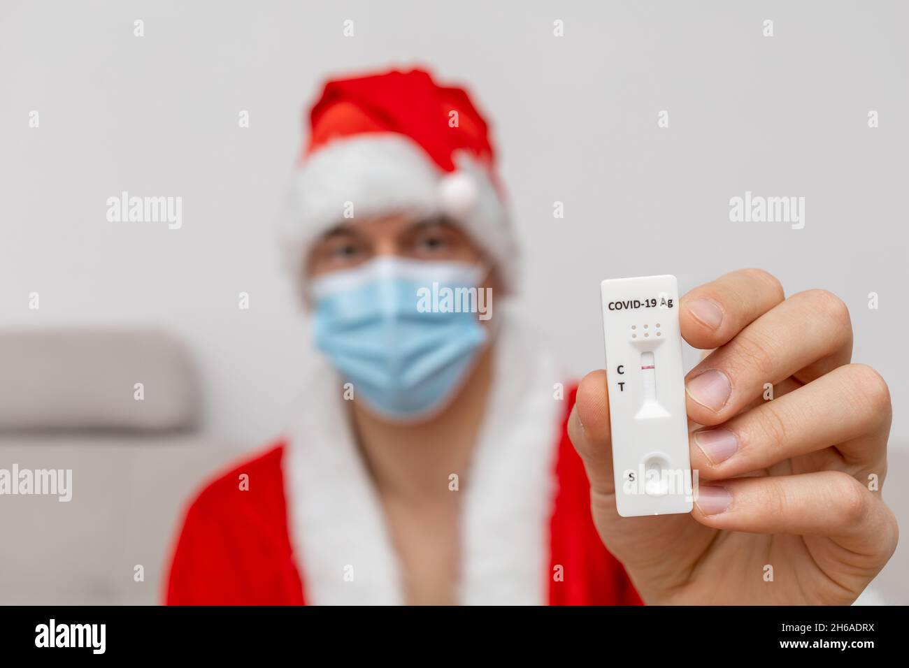 Mann mit Weihnachtsmannhut, der das Testergebnis zeigt Stockfoto