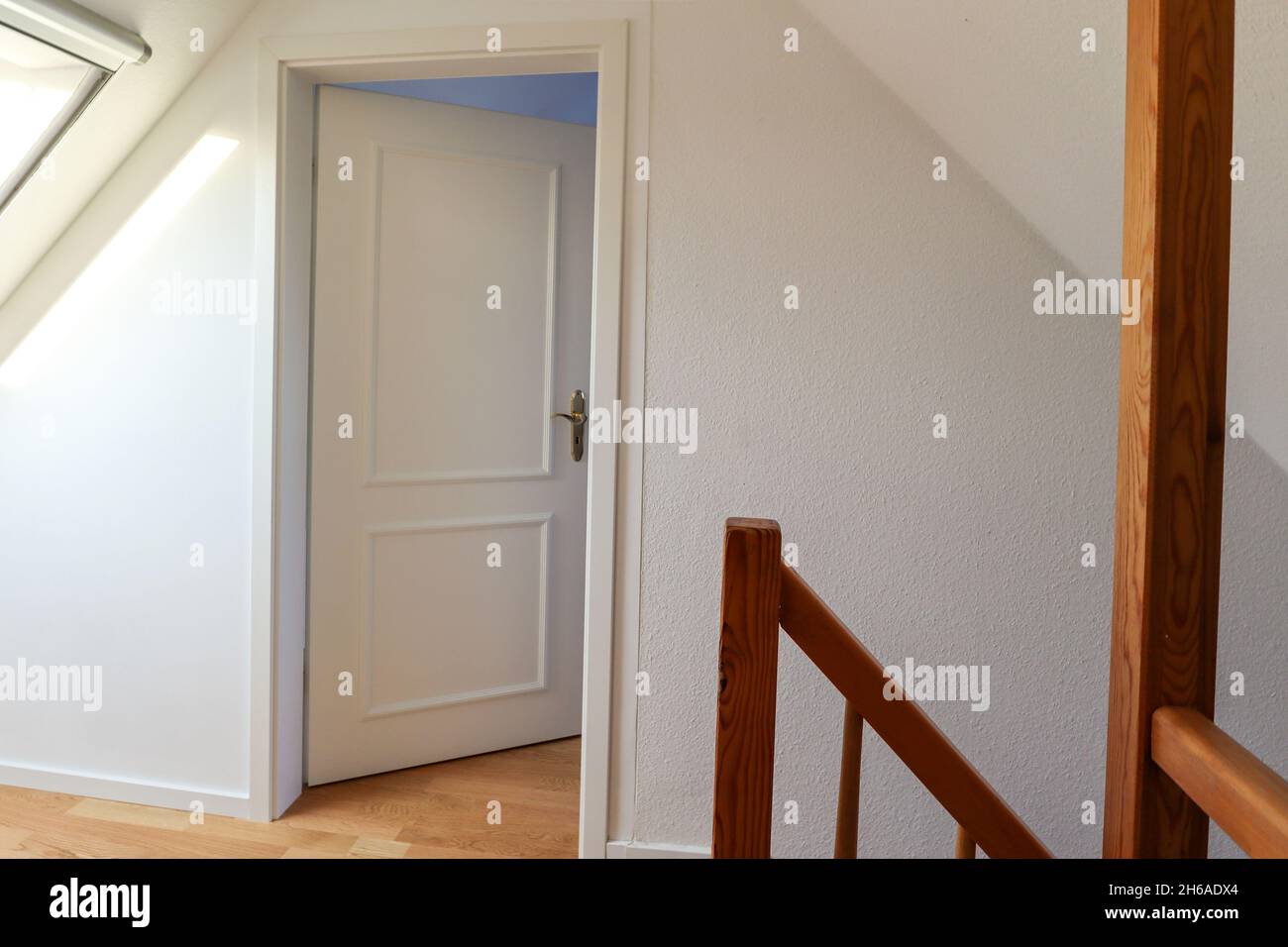 Umzug - Umzug in eine neue Wohnung - Tür zu einem modernen Wohnzimmer auf dem Dachboden, altes Haus zu einem neu renovierten Baugrundstück Stockfoto