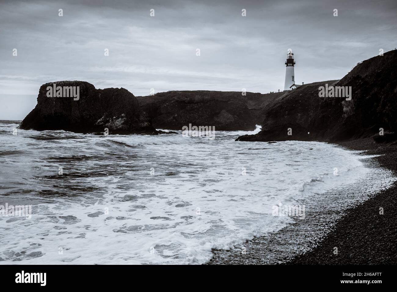 Schwarz-weißer Yaquina Head Leuchtturm und Kieselstrand Stockfoto
