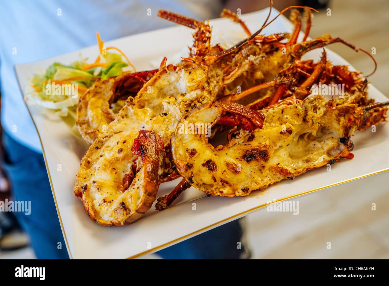 Nahaufnahme von frisch gegrillten Hummerschwänzen, serviert mit Gemüsesalat und Rise. Hochwertige Fotos Stockfoto