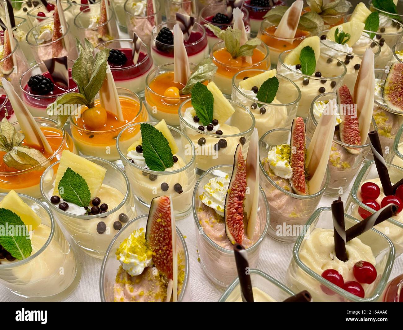 Sortiment an bunten und dekorativen Süßigkeiten und Desserts aus Glas. Verschiedene Mousse, Cremes, Panna Cotta. Stockfoto
