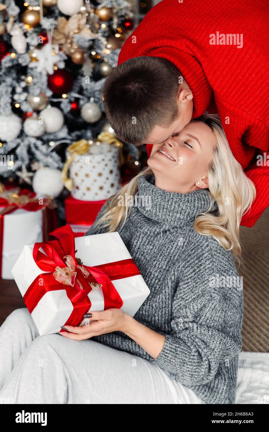 Überraschung Weihnachtsgeschenke: Fröhliche Mann und Frau verbringen festlichen Morgen bei Weihnachtsbaum Austausch Geschenk Stockfoto