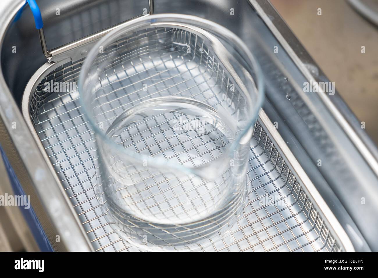 Chemischer Becher im Ultraschallbad zum Reinigen und Entgasen von Flüssigkeiten oder zum Auflösen von Substanzen. Stockfoto