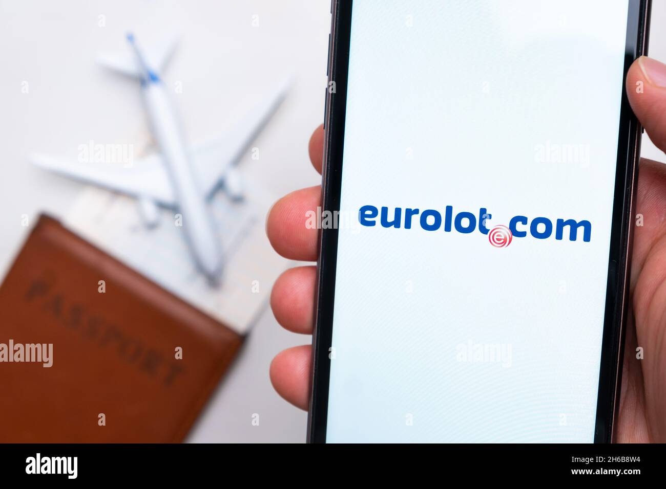 Eurolot com Airlines Unternehmens-App oder -Logo auf einem Mobiltelefon mit Reisepass, Bordkarte und Flugzeug im Hintergrund, September 2021, San Francisco, USA. Stockfoto