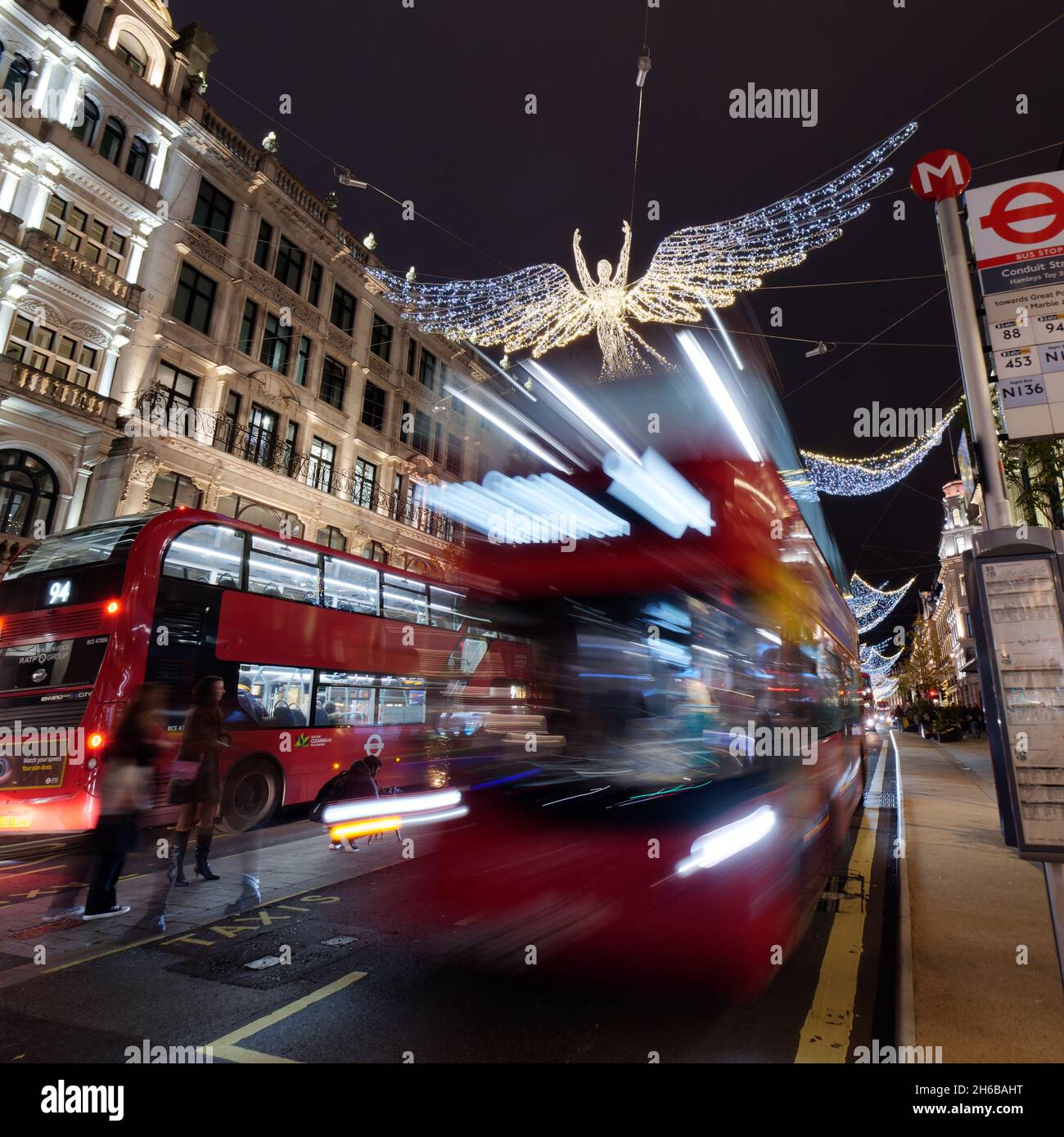 London, Greater London, England, 13 2021. November: Weihnachtliche Lichtstimmung auf der Regent Street bei Nacht, wenn Busse vorbeifahren. Stockfoto