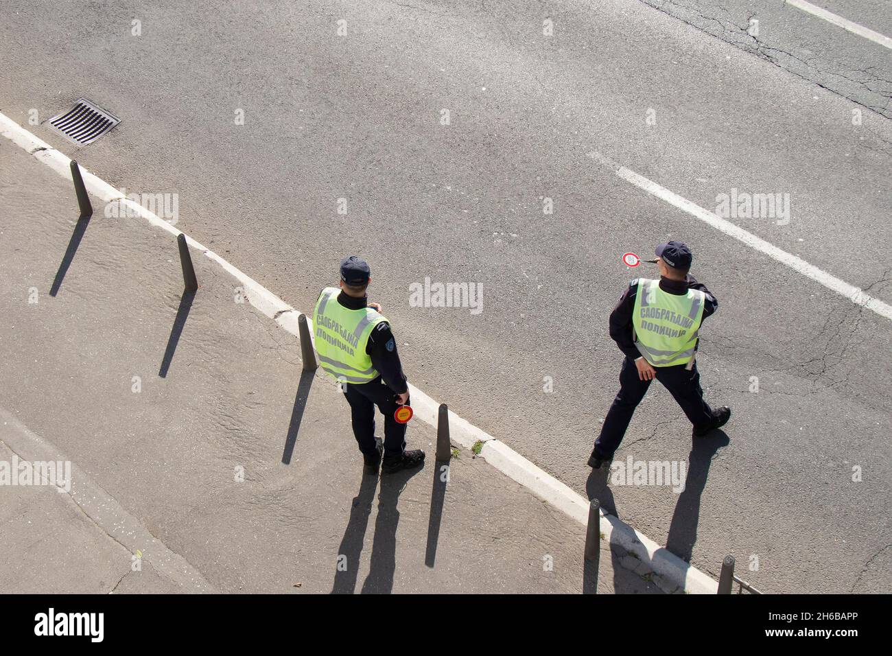 Belgrad, Serbien - 25. Oktober 2021: Zwei Verkehrspolizisten im Einsatz, die Fahrzeuge zur Kontrolle anhalten, in der hinteren, hochwinkligen Ansicht Stockfoto