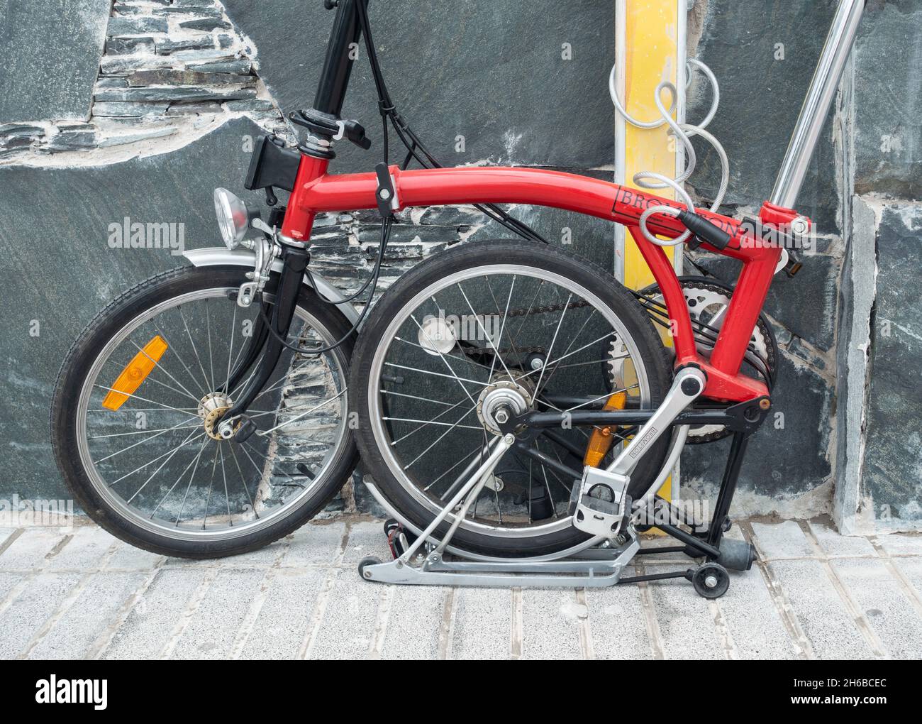 Brompton Faltrad, Fahrrad gesperrt, an Straßenschild gekettet Stockfoto
