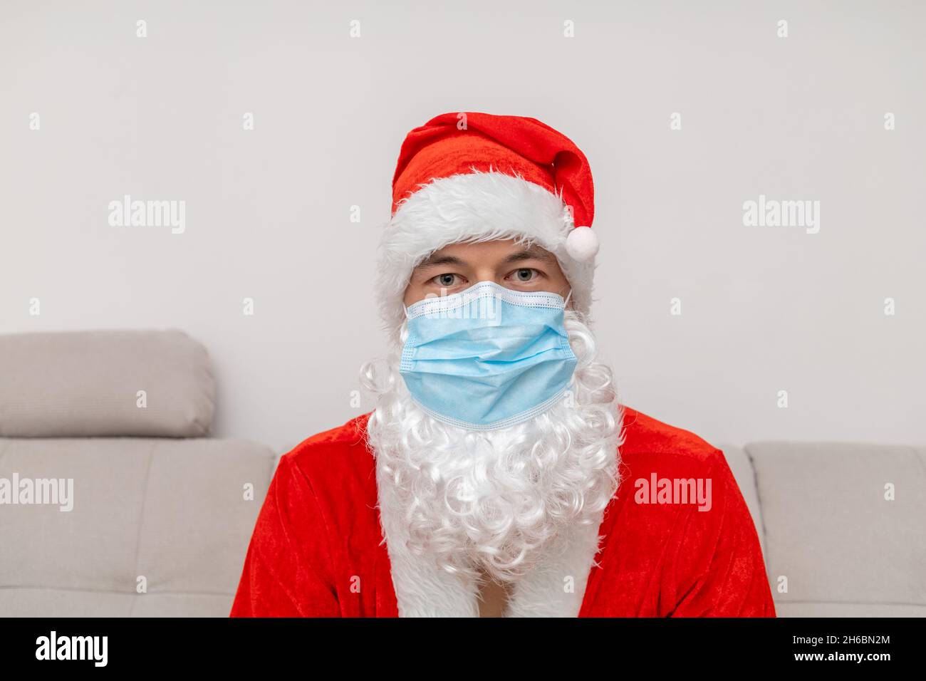 Portrait Mann in Weihnachtsmann Hut und Gesichtsmaske Stockfoto