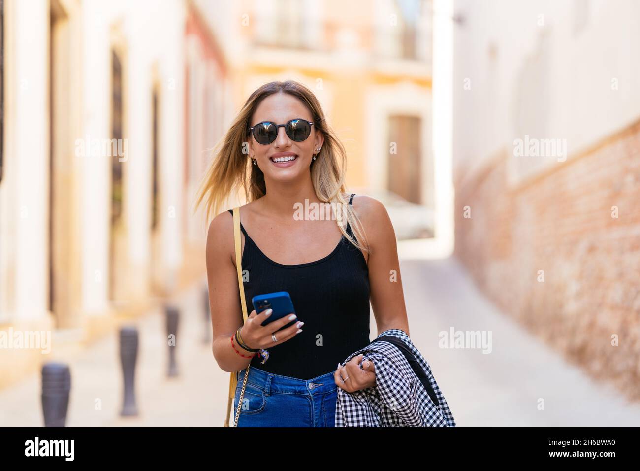 Positive Frau mit Smartphone und Kamera Stockfoto