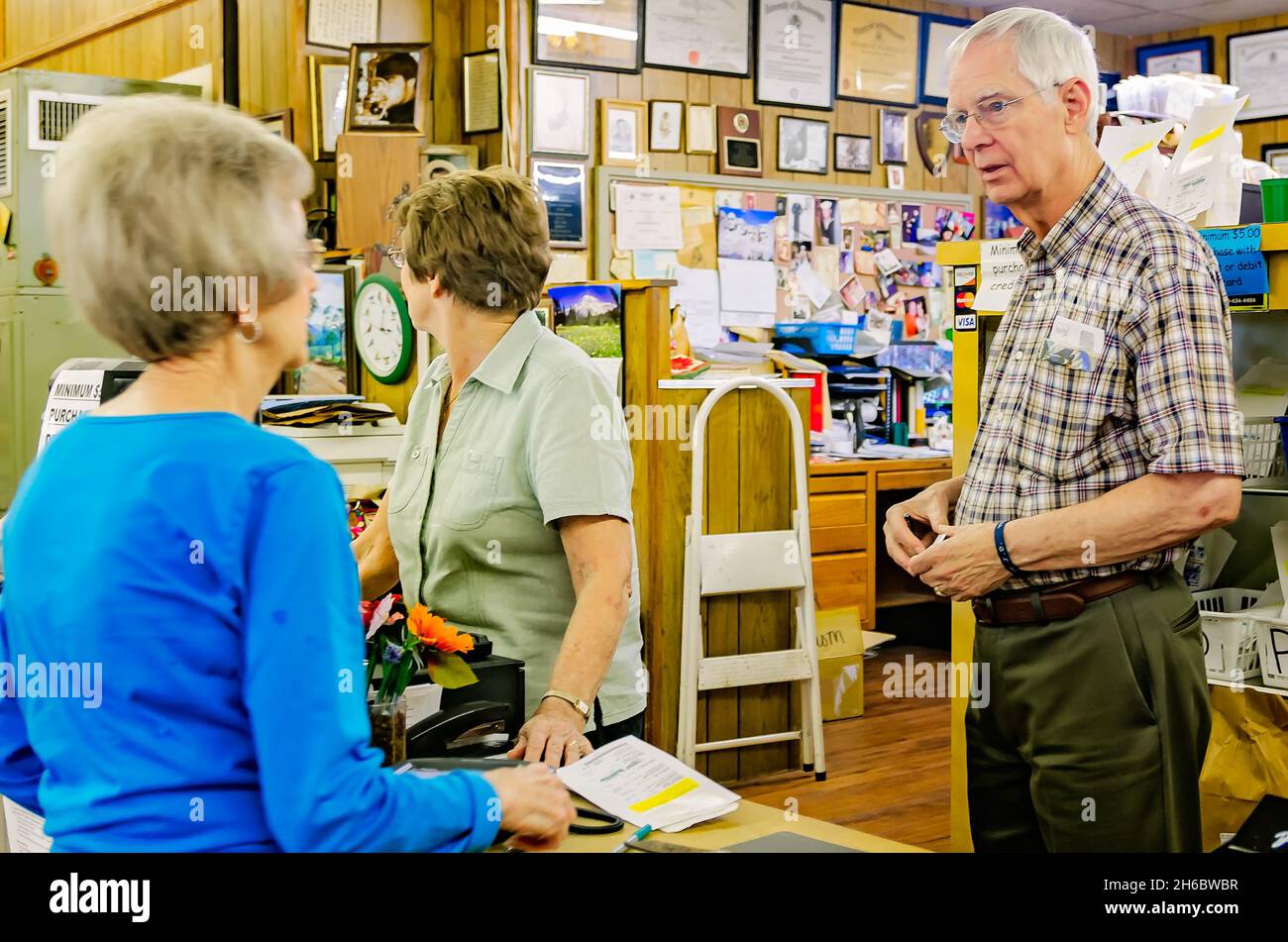 Der Apotheker Robert Turnage spricht mit einem Kunden im Turnage Drug Store in Water Valley, Mississippi. Die Familienapotheke wurde 1905 gegründet. Stockfoto