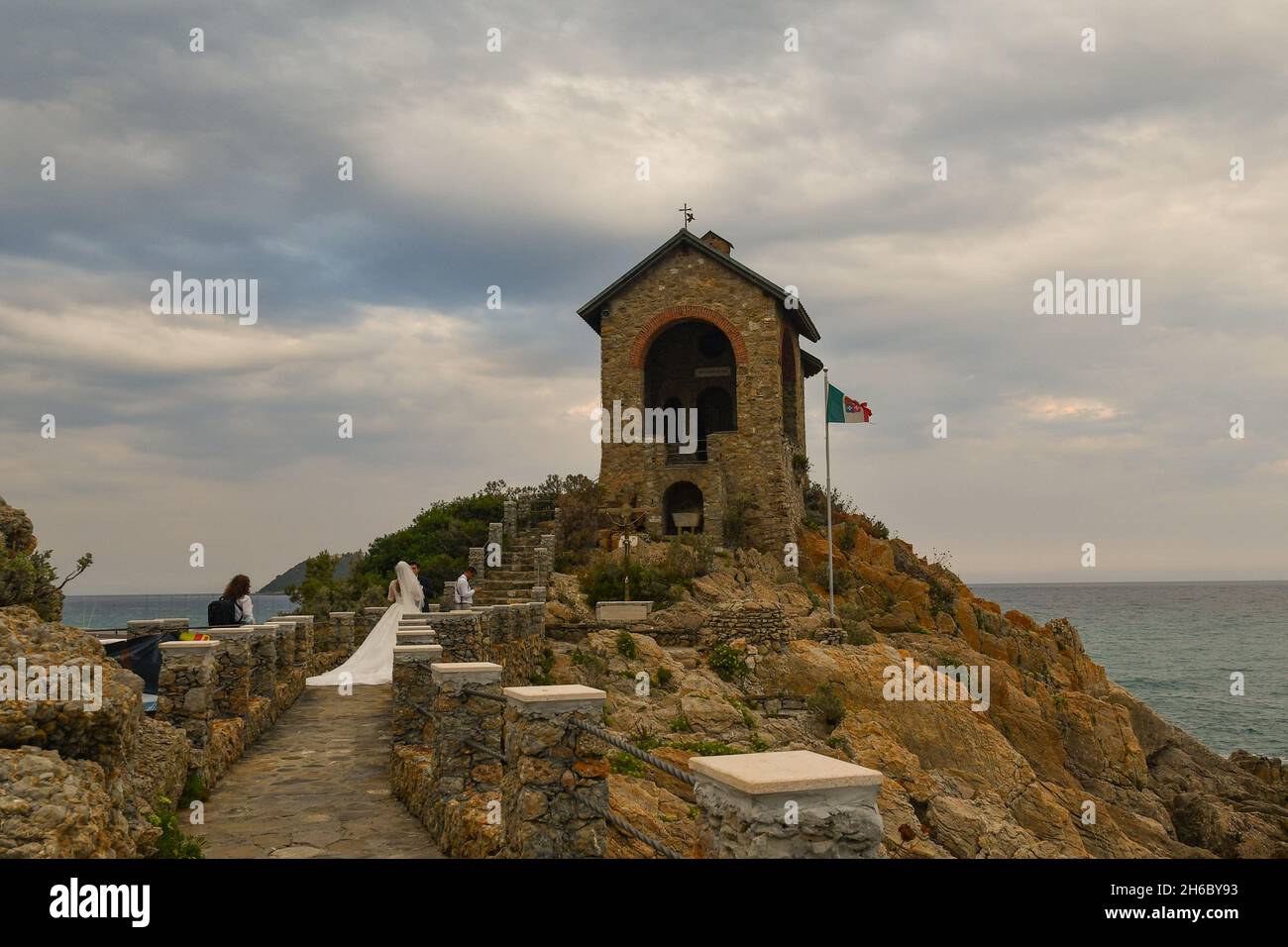 Ein frisch verheiratetes Paar während des Fotoshootings der Hochzeit in der Kapelle von Alassio, die sich auf einer Klippe mit Blick auf das Meer, Savona, Ligurien, Italien befindet Stockfoto