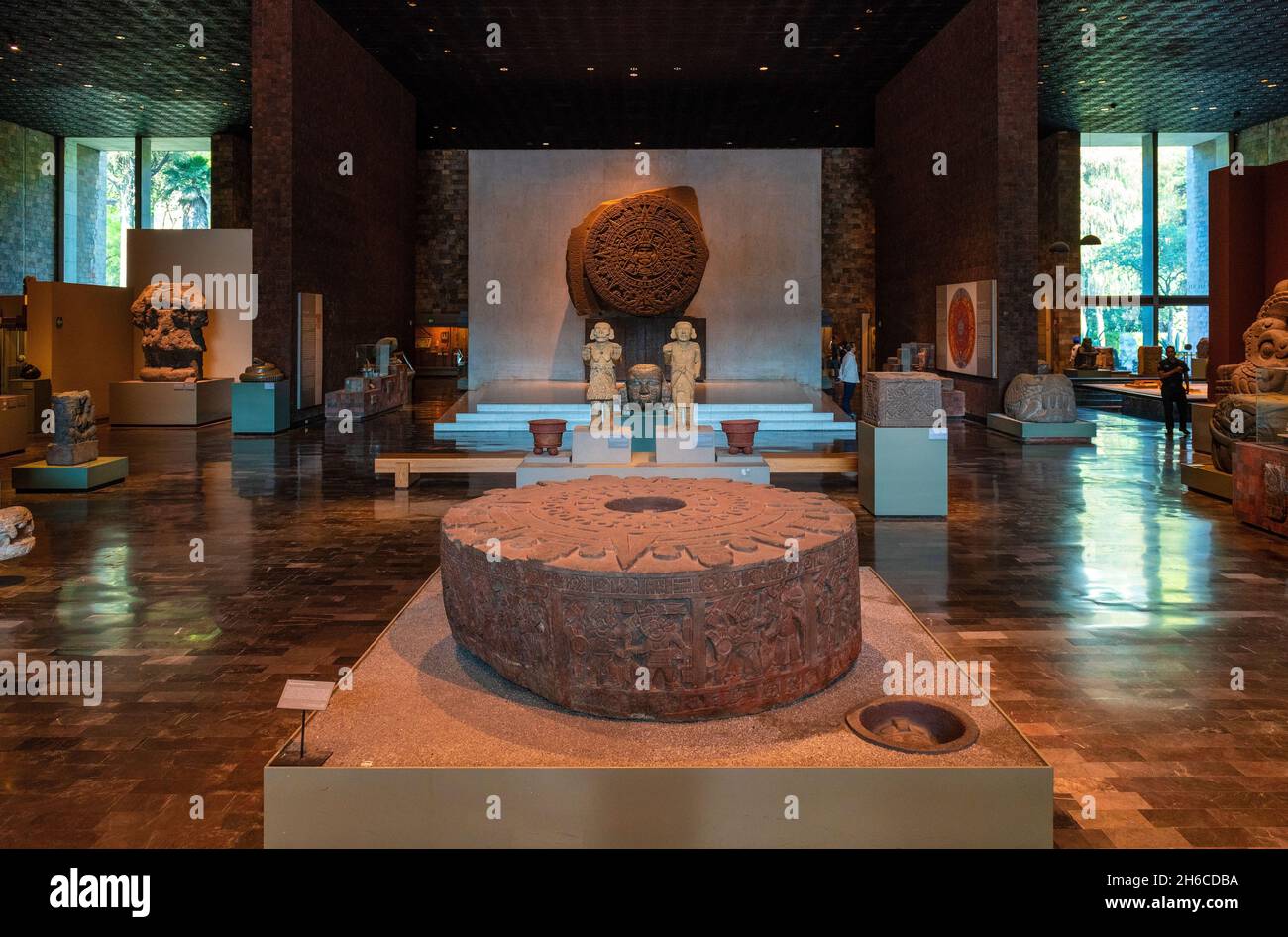 Innenansicht des Antrhopology Museums mit aztekischen archäologischen Objekten und dem aztekischen Sonnenkalender im Hintergrund, Mexiko-Stadt, Mexiko. Stockfoto