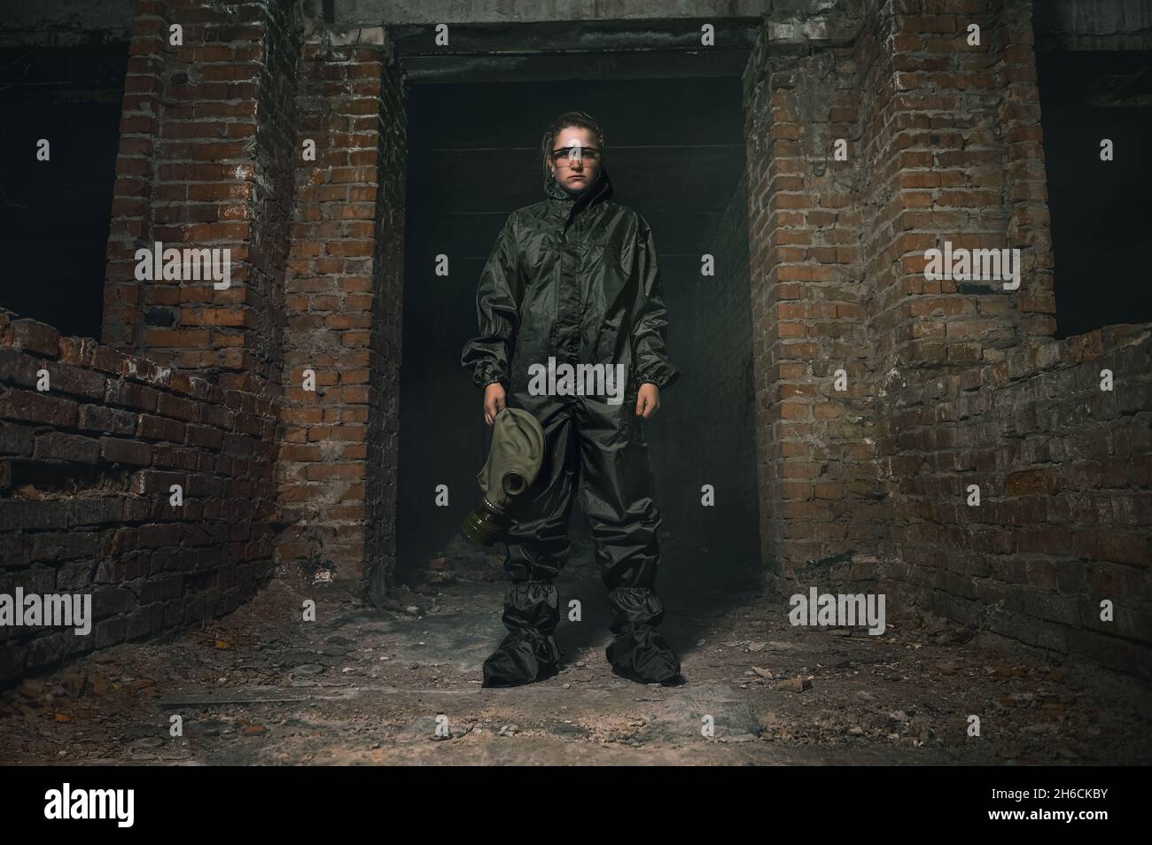 Schöne militärische Mädchen. Porträt einer Frau mit Gasmaske in einem zerstörten Gebäude. Post-Apokalypse-Konzept Stockfoto