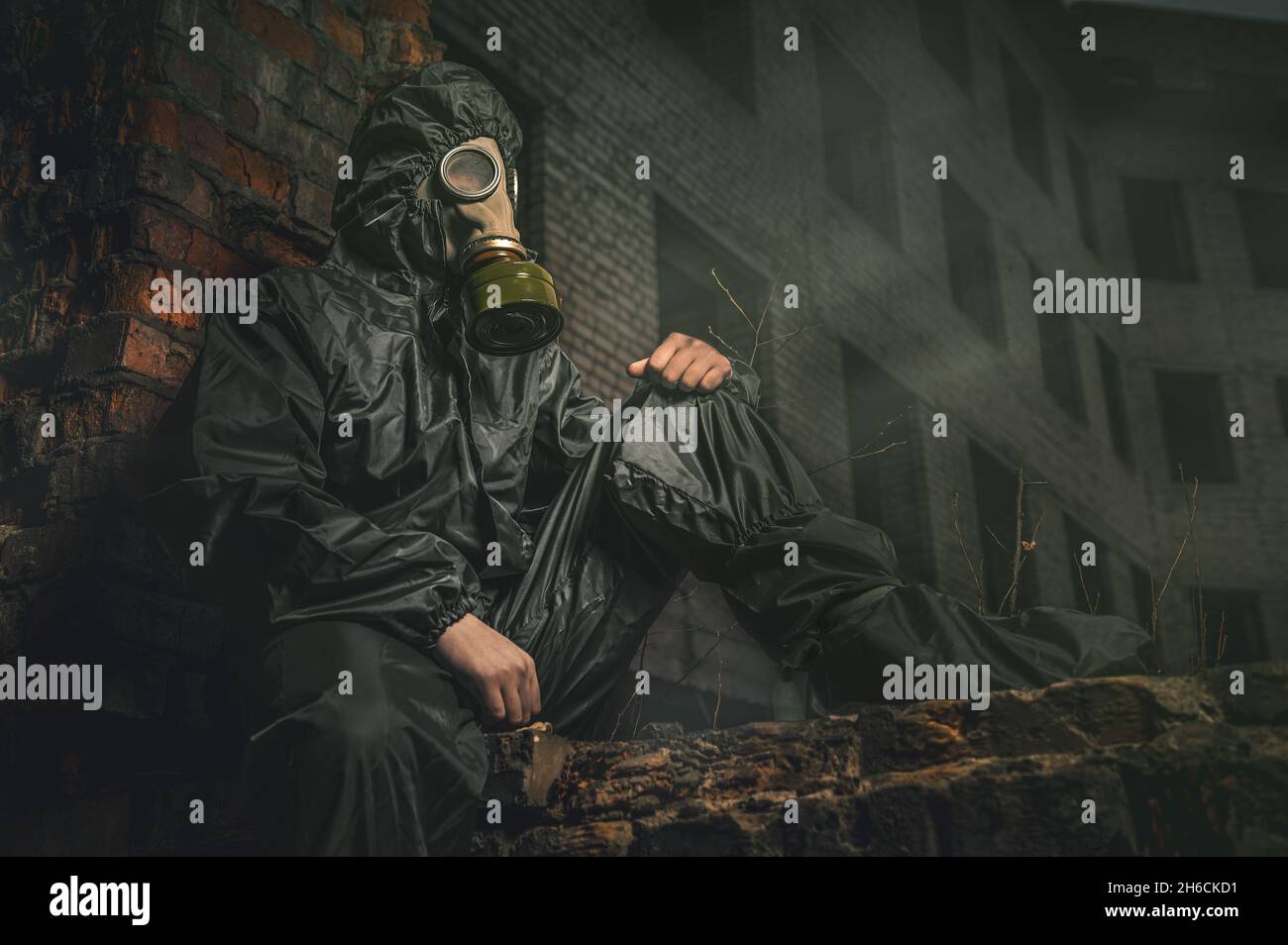 Schöne militärische Mädchen. Porträt einer Frau mit Gasmaske in einem zerstörten Gebäude. Post-Apokalypse-Konzept Stockfoto