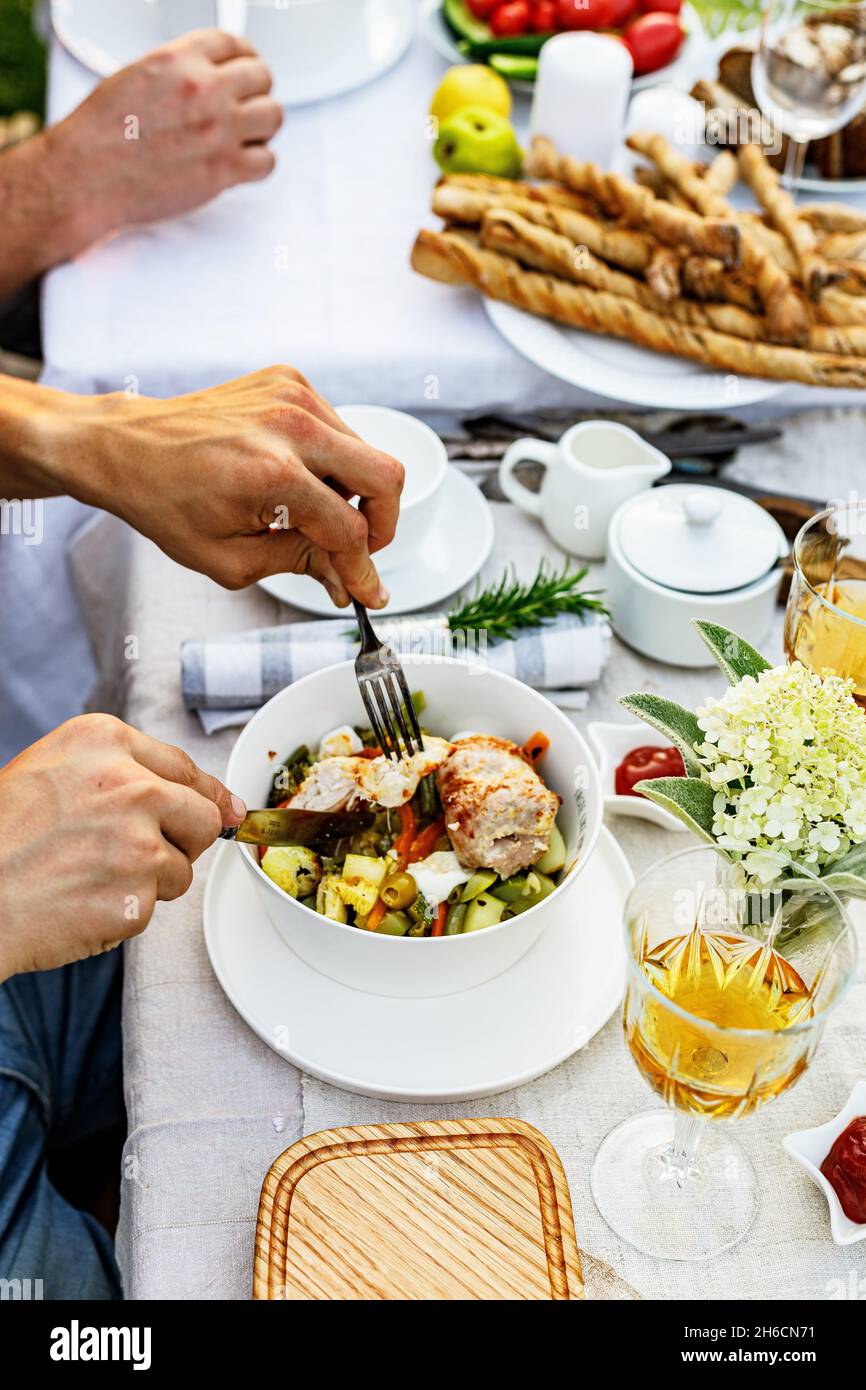 Ein festliches Familienessen oder Grillen im Sommergarten. Familienfreizeitund Feier- und Essenskonzept. Die Leute essen auf einer Gartenparty. BBQ, V Stockfoto