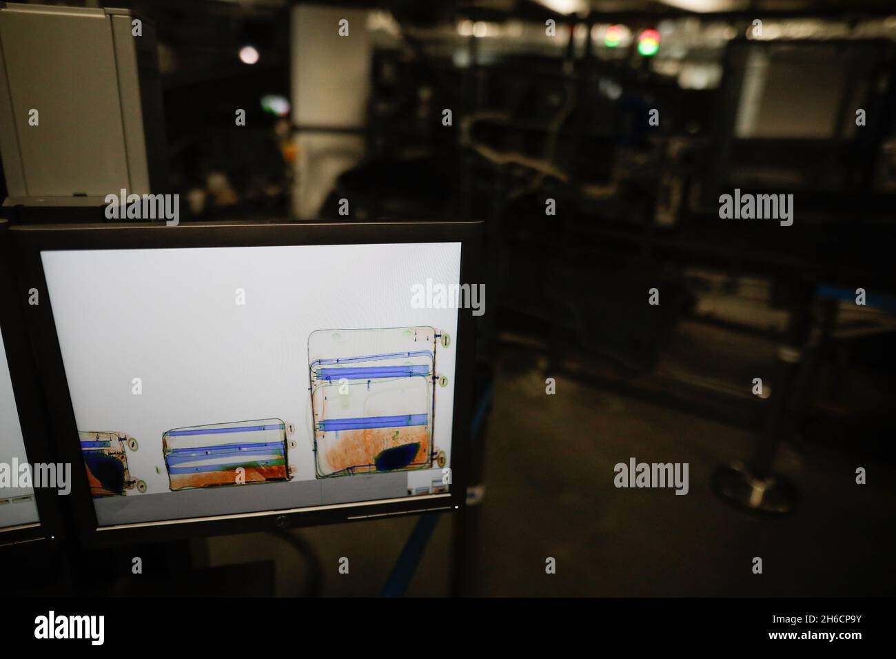 Bild mit geringer Schärfentiefe (selektiver Fokus) mit einem Bildschirm, auf dem Gepäck in einem Röntgenscanner an einem Flughafen - Sicherheitskontrolle am Flughafen gezeigt wird. Stockfoto