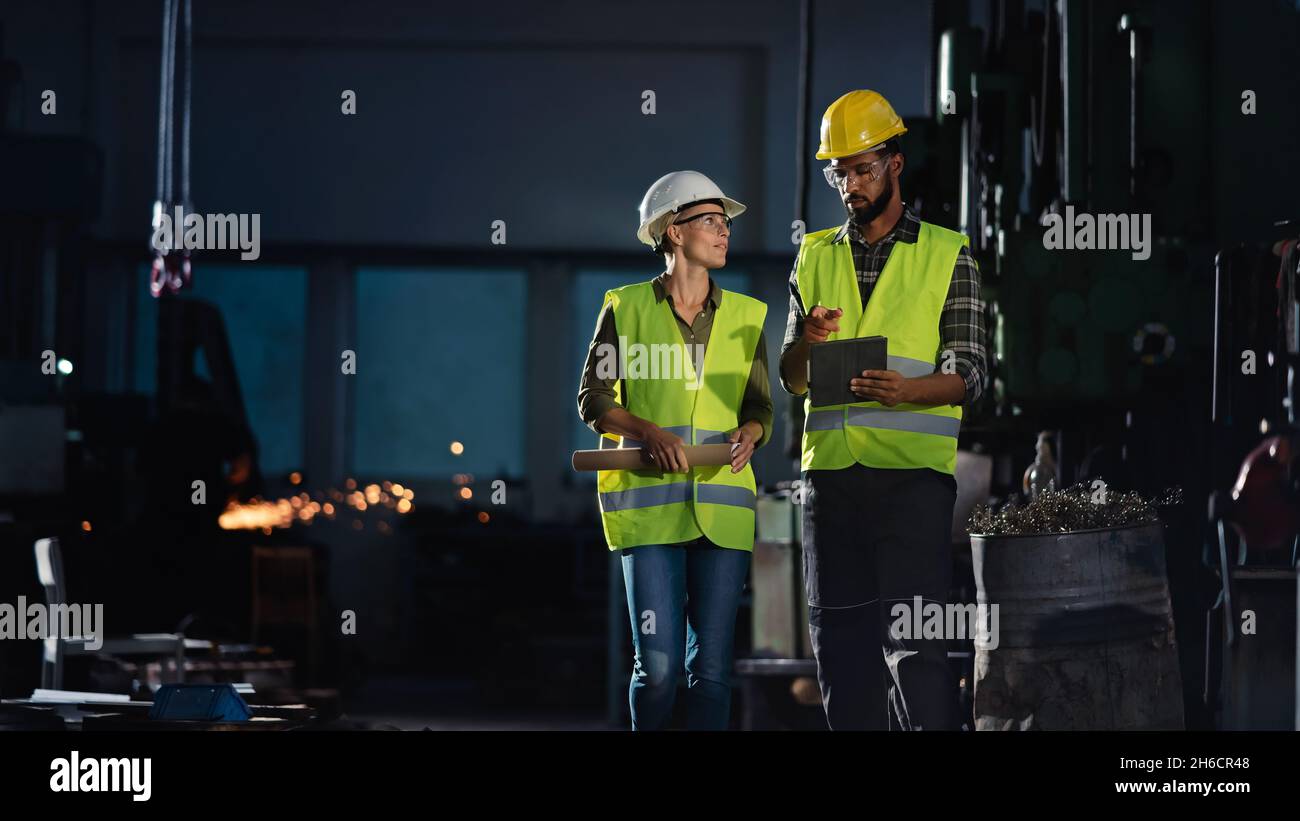 Industrieinspektoren, die in Innenräumen in einer Metallwerkstatt eine allgemeine Überprüfung durchführen. Stockfoto