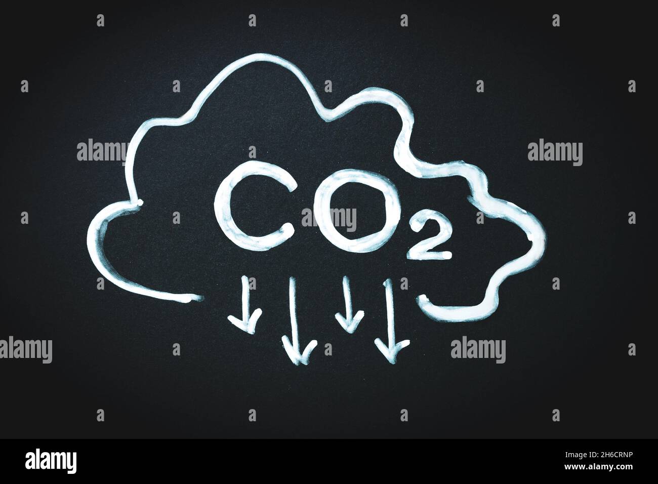 CO2-Zeichen und Pfeile zeigen nach unten und Wolke auf schwarzem Memo-Board. Reduzierung der Kohlendioxidemissionen, Begrenzung der globalen Erwärmung und Konzept des Klimawandels Stockfoto