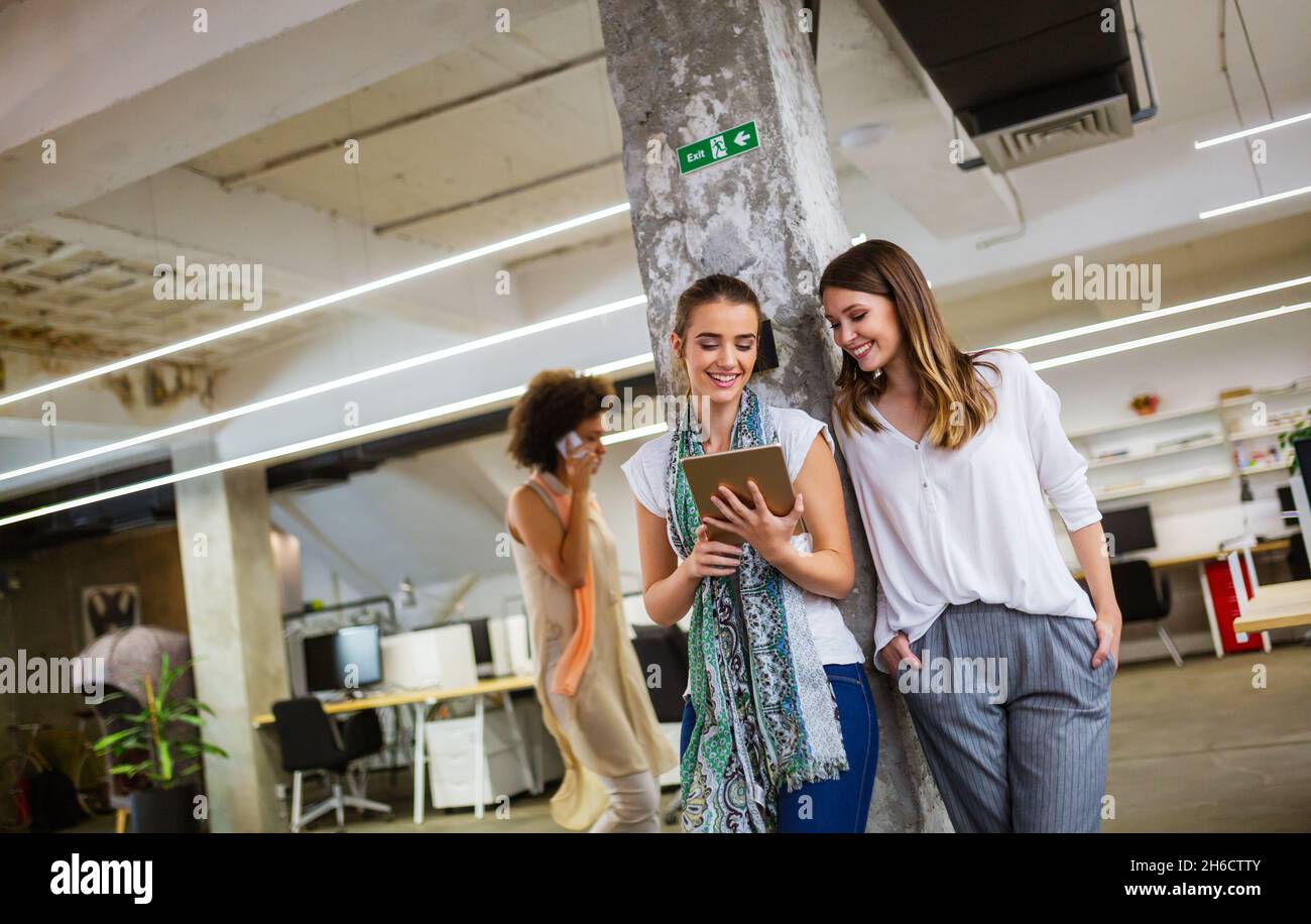 Attraktive Geschäftsfrau, die sich während der Büropause mit Kollegen unterhalten kann Stockfoto