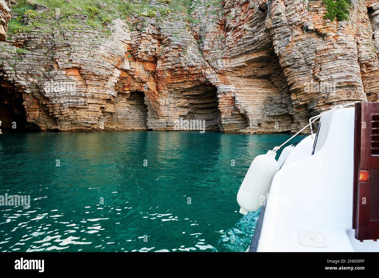 Kleines Boot erkundet felsige Küste und Höhlen und das tropische Meer. Exotische Reiseziele Stockfoto
